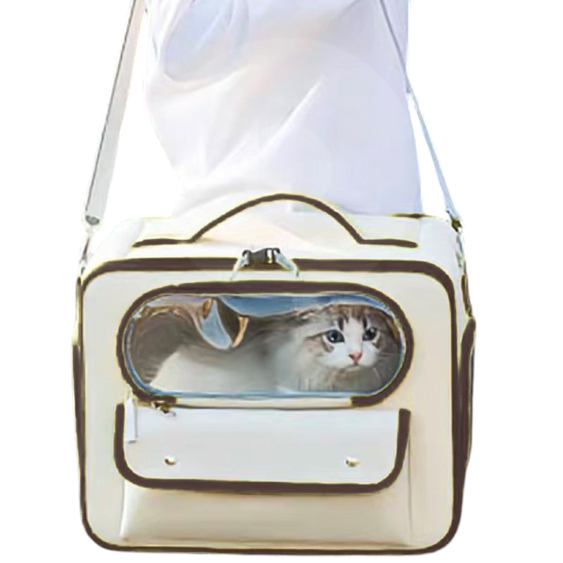 The Tailored Tail beige Oxford fabric pet travel bag with a transparent window and shoulder strap carrying a cat