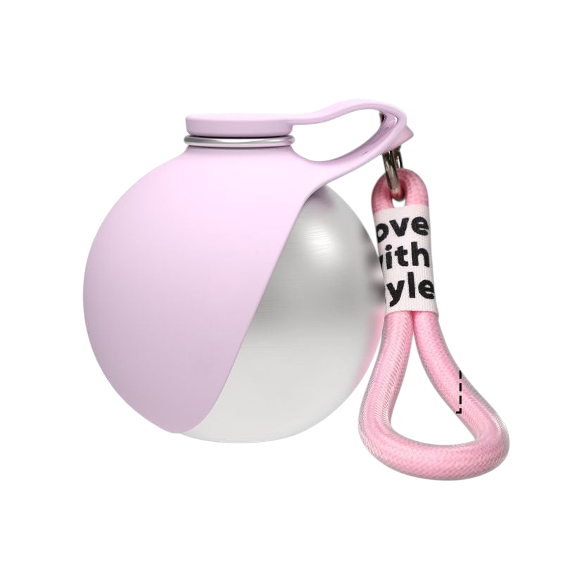 The Tailored Tail collapsible pet water bottle in soft pink with a stainless steel interior and carrying strap
