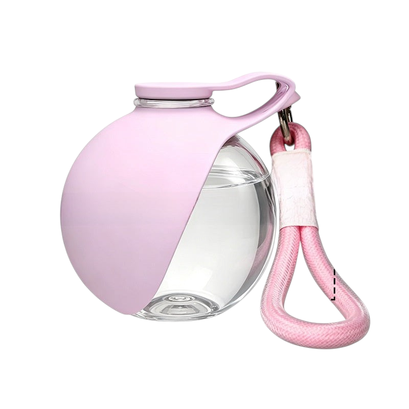 The Tailored Tail collapsible pink pet water bottle with a clear circular body and a convenient carrying strap.