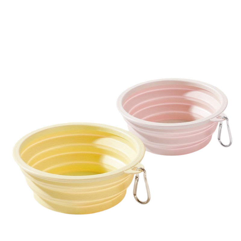 The Tailored Tail foldable silicone pet bowls in yellow and pink with attached carabiner clips for travel.