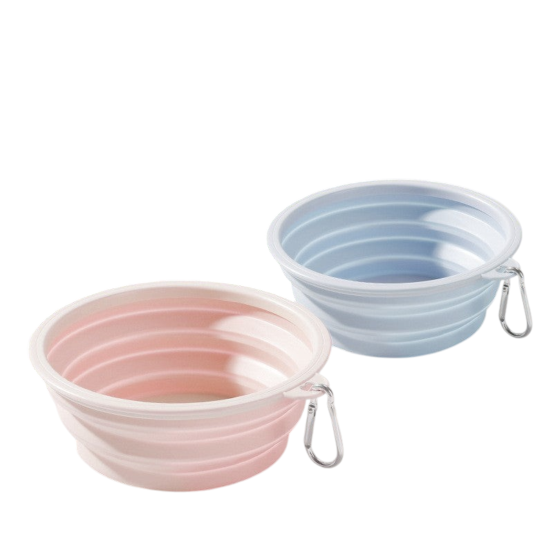 The Tailored Tail foldable silicone pet bowls in pastel pink and blue with attached carabiner clips for travel.