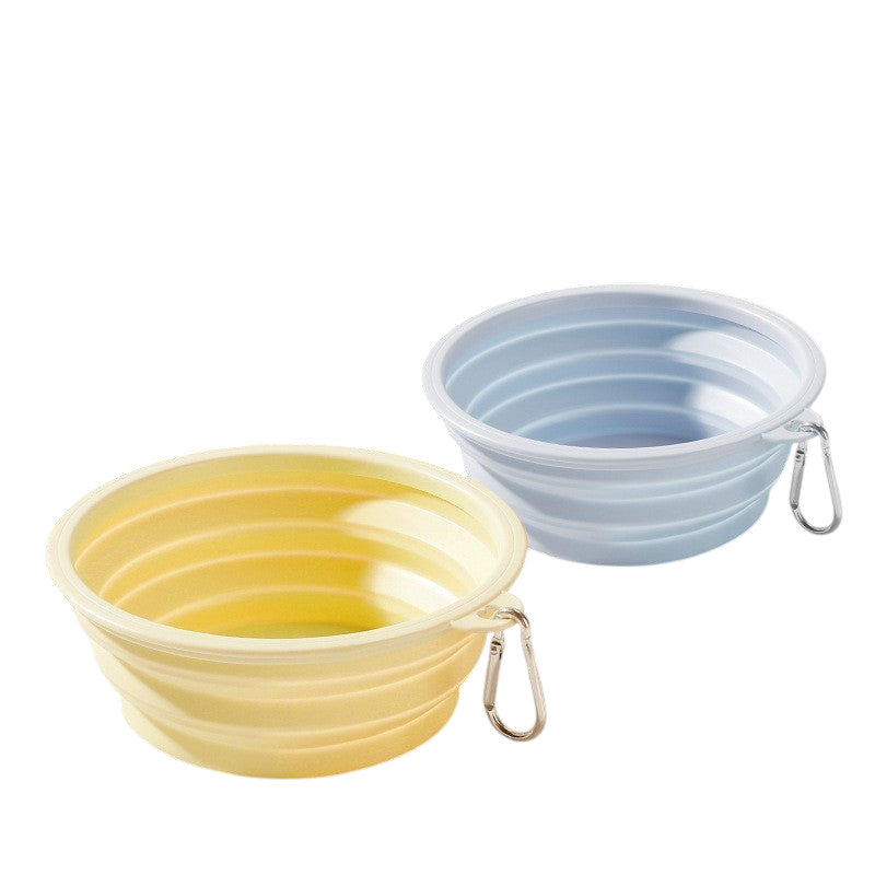 The Tailored Tail foldable silicone pet bowls in yellow and blue with attached metal carabiners for travel.