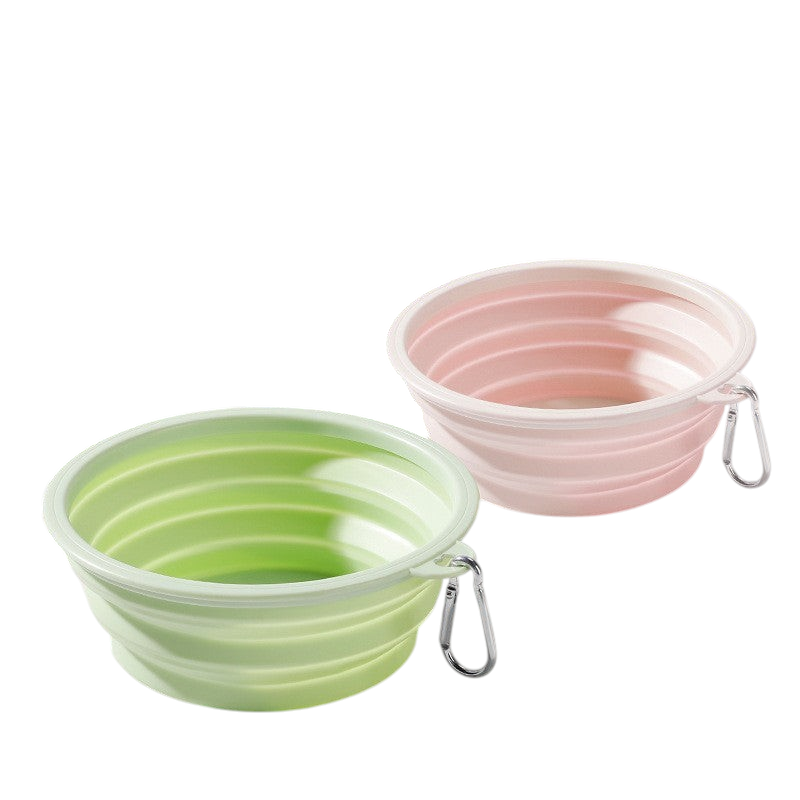 The Tailored Tail foldable silicone pet bowls in green and pink with attached carabiner clips for travel.