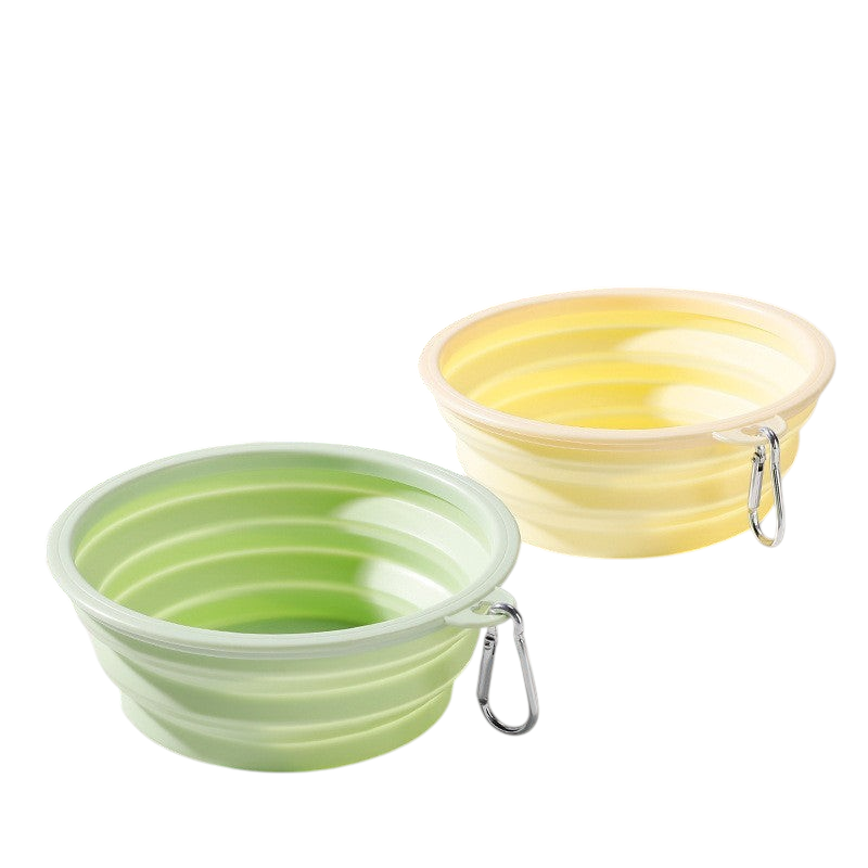 The Tailored Tail foldable silicone pet bowls in green and yellow with attached metal carabiner clips for travel.
