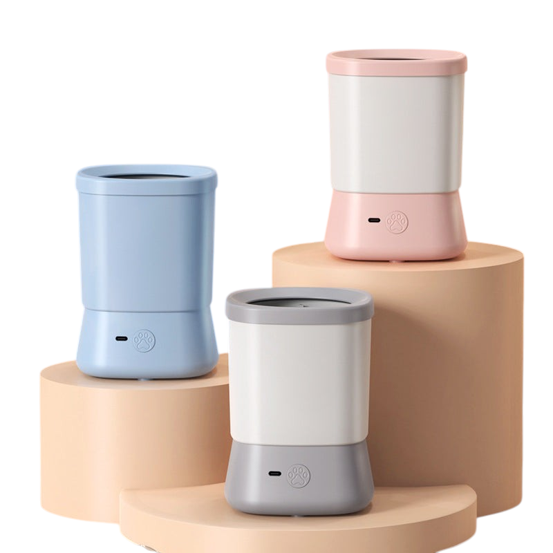 The Tailored Tail electric pet paw cleaners in blue, pink, and grey on display stands for dog and cat grooming.