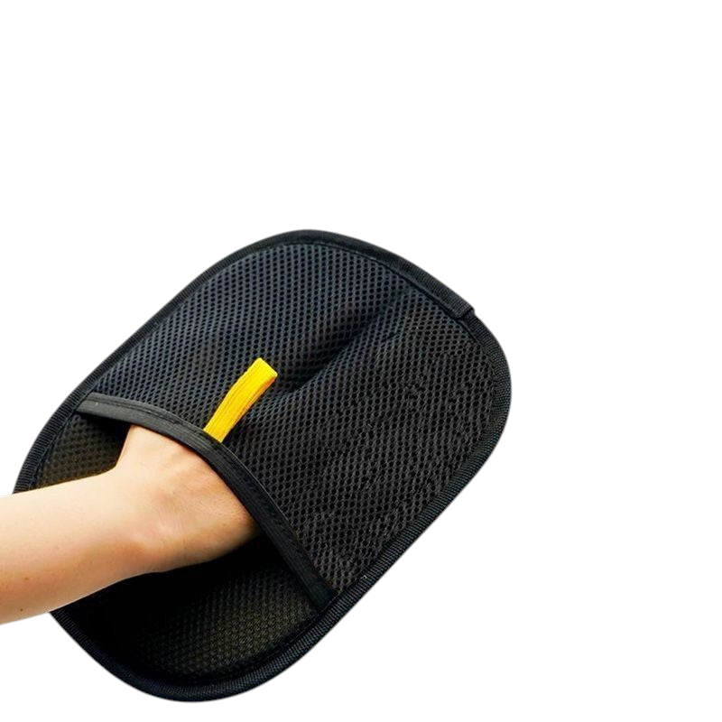The Tailored Tail black electrostatic pet hair removal glove worn on a hand for cleaning fabric surfaces