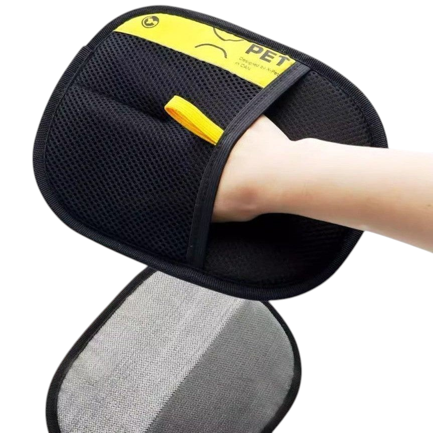 The Tailored Tail electrostatic pet hair remover glove in black and yellow being worn on a hand
